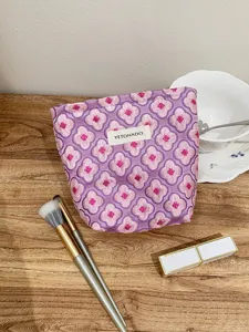 Detail shot of purple jacquard cosmetic bag featuring pink flower pattern and portable drawstring.