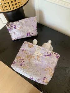 Detailed view of the purple floral brocade cosmetic bag featuring elegant embroidery and storage.