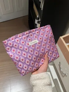 Floral jacquard cosmetic bag with convenient zipper closure, spacious pink and purple storage pouch.