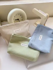Corduroy cosmetic bag detail, soft fabric storage pouch, daily travel makeup organizer.