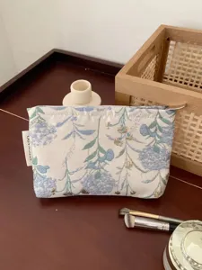 Detailed view of fresh floral print cosmetic pouch, portable travel makeup storage bag.