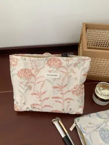 Portable large capacity floral makeup bag for travel cosmetic and skincare storage.
