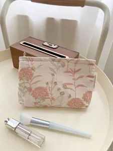Floral cosmetic bag detail, elegant pink and green embroidered pattern for daily travel.