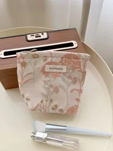 Detailed shot of the fresh floral cosmetic bag fabric texture, showing portable design.
