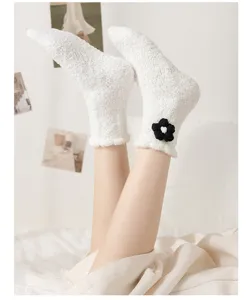 Gemütliche weiße flauschige Korallenfleece Schlafsocken mit schwarzer Blume für den Winter