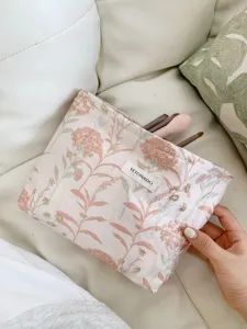Floral makeup bag detail showcasing elegant botanical embroidered fabric for travel