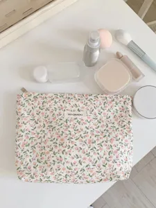 Detail shot of the floral cosmetic bag in a clean vanity setup, showing delicate fabric texture.