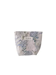 Detailed view of fresh floral cosmetic storage bag with woven label, compact and portable.