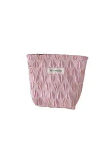 Pink cosmetic bag with 3D heart pattern, portable travel makeup pouch with zipper closure.