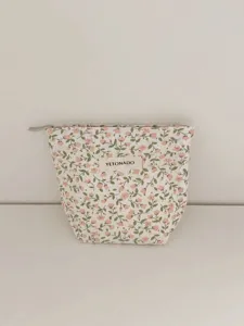 Close-up detail of the vintage floral cotton makeup bag with secure zipper and fabric label.