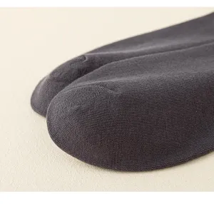 Detailopname van de teen van een donkergrijze katoenen sok met fijne gebreide textuur.