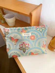 Detail view of large capacity cosmetic bag with traditional crane and butterfly pattern fabric.
