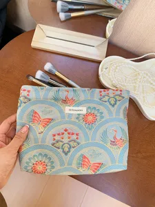 Detailed view of large capacity cosmetic bag with crane and butterfly pattern, aesthetic props.