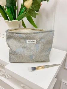 Detail shot of the embossed rose cosmetic bag, showing intricate fabric texture and gold zipper.