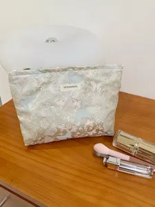 Jacquard butterfly cosmetic bag detail showing soft fabric texture and elegant zipper closure.