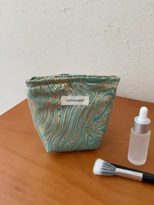 Detailed shot of a luxury jacquard cosmetic bag featuring a golden wave pattern.