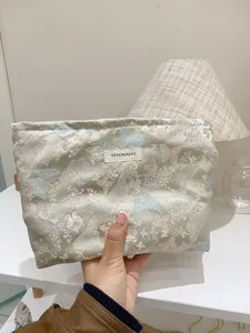 Close-up detail of the jacquard butterfly cosmetic bag, showing the textured fabric.
