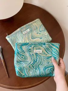 Stylish jacquard cosmetic bag with large capacity, elegant swirl pattern travel storage pouch.