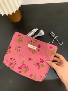Floral canvas makeup pouch detail showing cute pink pattern, compact cosmetic storage bag.
