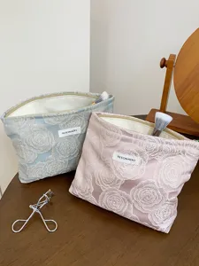 Detailed view of the embossed rose cosmetic bag, showing fine fabric texture and neat zipper.