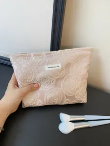 Detail shot of the pink embossed rose cosmetic bag, showing exquisite embroidery and texture.