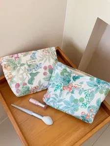 Vue détaillée de la trousse de maquillage en coton floral, imprimé botanique et fermeture.