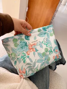 Détail de la trousse de maquillage en coton à fleurs, grand étui zippé pour cosmétiques.
