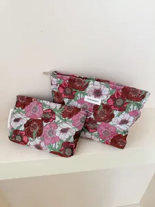 Detail view of floral jacquard cosmetic bags set, elegant makeup pouch and coin purse.