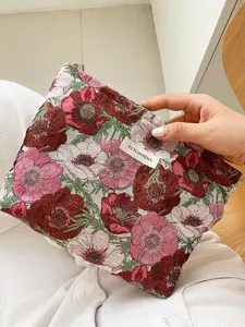 Detailed view of floral jacquard cosmetic pouch, elegant fabric makeup bag for women.