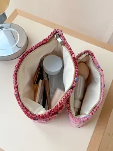 Detailed close-up showing pink tweed cosmetic pouch interior with makeup storage features.