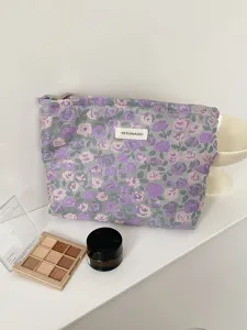 Floral pattern cosmetic pouch detail view, vintage woven fabric makeup bag with zipper closure.