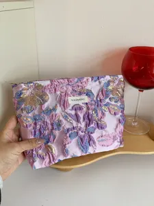 Purple floral cosmetic pouch for women, elegant relief makeup bag and portable clutch handbag.