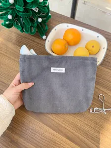 Detailed view of gray corduroy cosmetic bag, soft textured travel makeup pouch and storage.