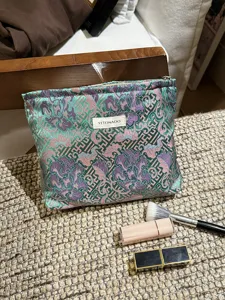 Detail view of Chinese vintage floral cosmetic pouch, portable makeup storage bag for travel.