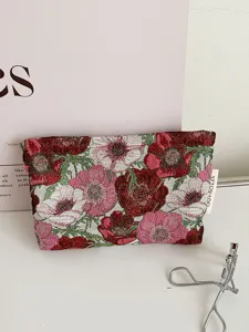 Vintage floral jacquard cosmetic bag close-up, stylish fabric travel makeup pouch detail.