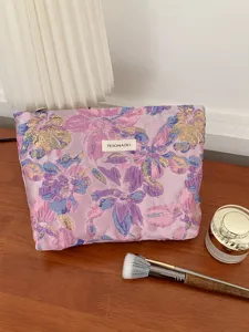 Detailed view of the purple embossed floral cosmetic bag, featuring large capacity and soft fabric.
