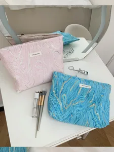 Large capacity pleated cosmetic bag with gold embossed texture, portable makeup storage pouch.