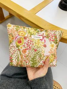 Floral canvas cosmetic bag with metal zipper, detailed view showing embossed fabric texture.