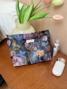 Detail view of floral jacquard cosmetic pouch with dark retro pattern and zipper closure.