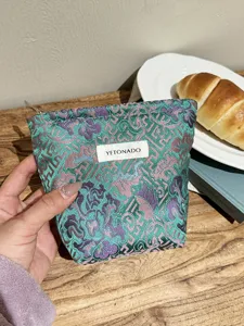 Close-up detail of vintage Chinese brocade makeup pouch with retro floral pattern.
