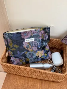 Detailed view of the vintage floral cosmetic pouch with smooth zipper and brand label inside basket.
