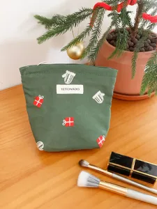 Green canvas Christmas embroidery cosmetic pouch detail view with gift pattern and brand label.