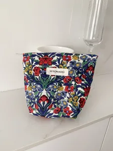 Vintage floral cosmetic bag detail shot, portable makeup storage pouch, travel toiletry organizer.