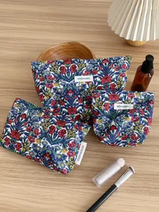 Detailed view of vintage floral cosmetic bags set with label details and fine fabric texture.
