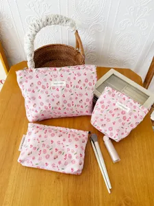 Detailed view of pink floral cosmetic bags set, showing fabric texture and storage design.
