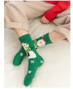 Close-up detail of thick green coral fleece Christmas snowman socks, soft and warm winter wear.