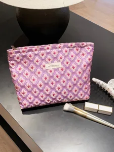 Close-up view of the purple floral jacquard pouch, showing fine texture and details.