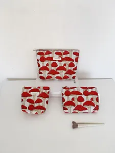 Close-up detail of ramie cotton canvas cosmetic storage bags with red mushroom print.