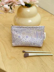 Floral jacquard cosmetic pouch with secure zipper, elegant makeup storage bag for travel.