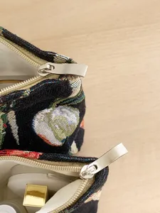 French retro tulip jacquard cosmetic bag detail showing fine texture and smooth metal zippers.